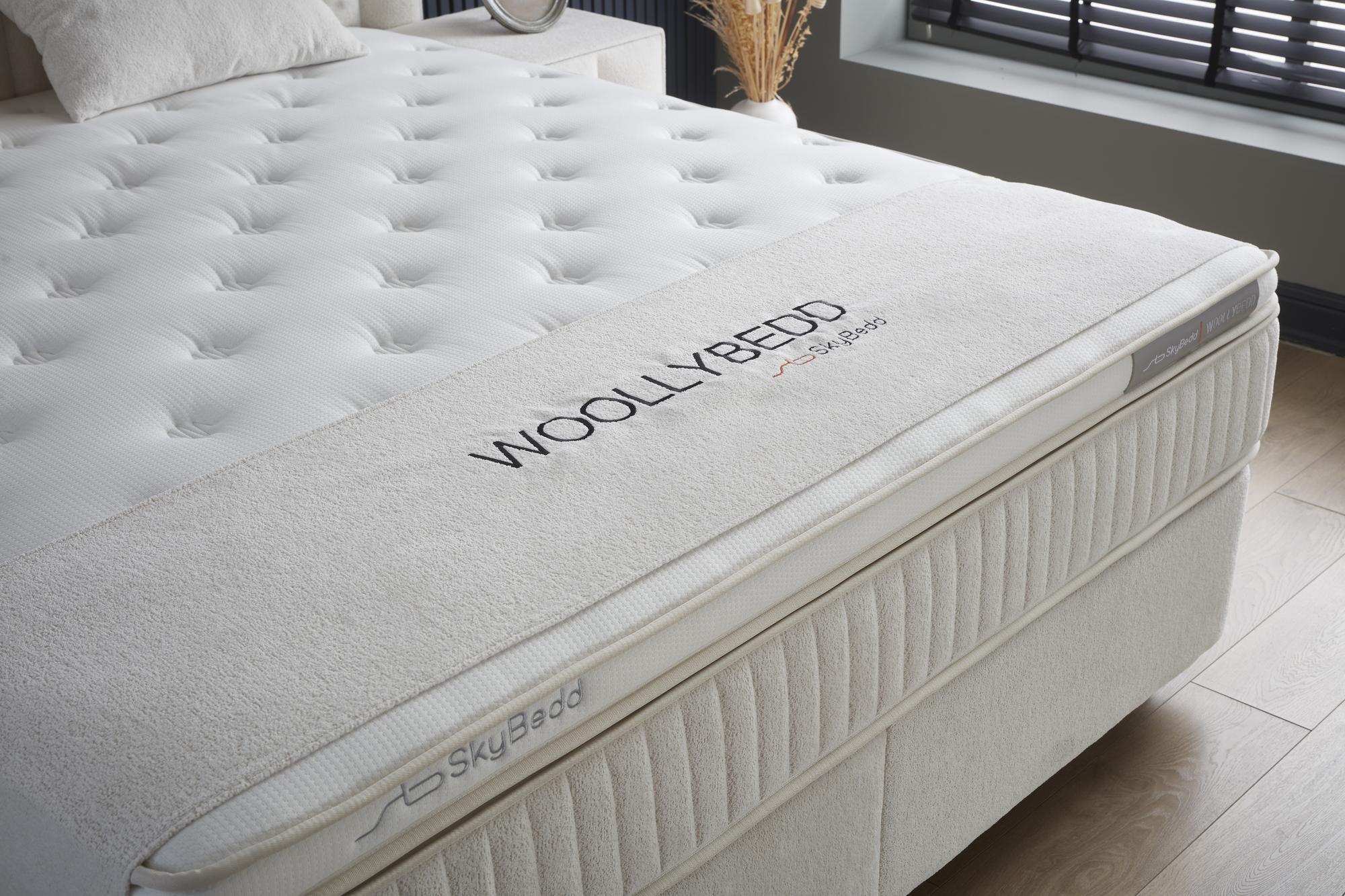 Boxspringbett WoollyBedd SkyBedd mit integrierter Matratze und Stauraum, gezeigt auf einem Bettgestell, ideal für günstigen, bequemen Schlaf bei SkyHome24.de.