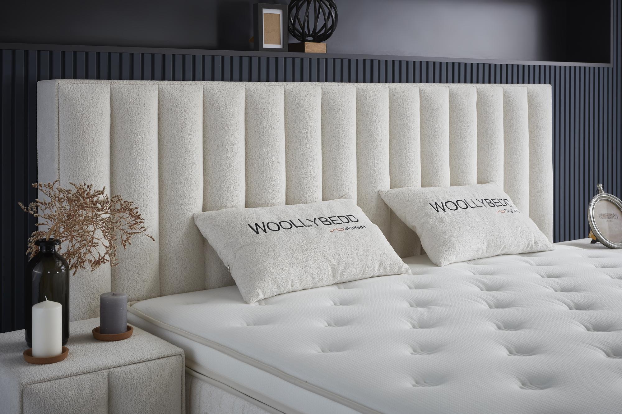 Boxspringbett 'WoollyBedd' mit integrierter Matratze und Stauraum, betont durch stilvolle, moderne Features. Luxuriös und günstig bei SkyHome24.de erhältlich.
