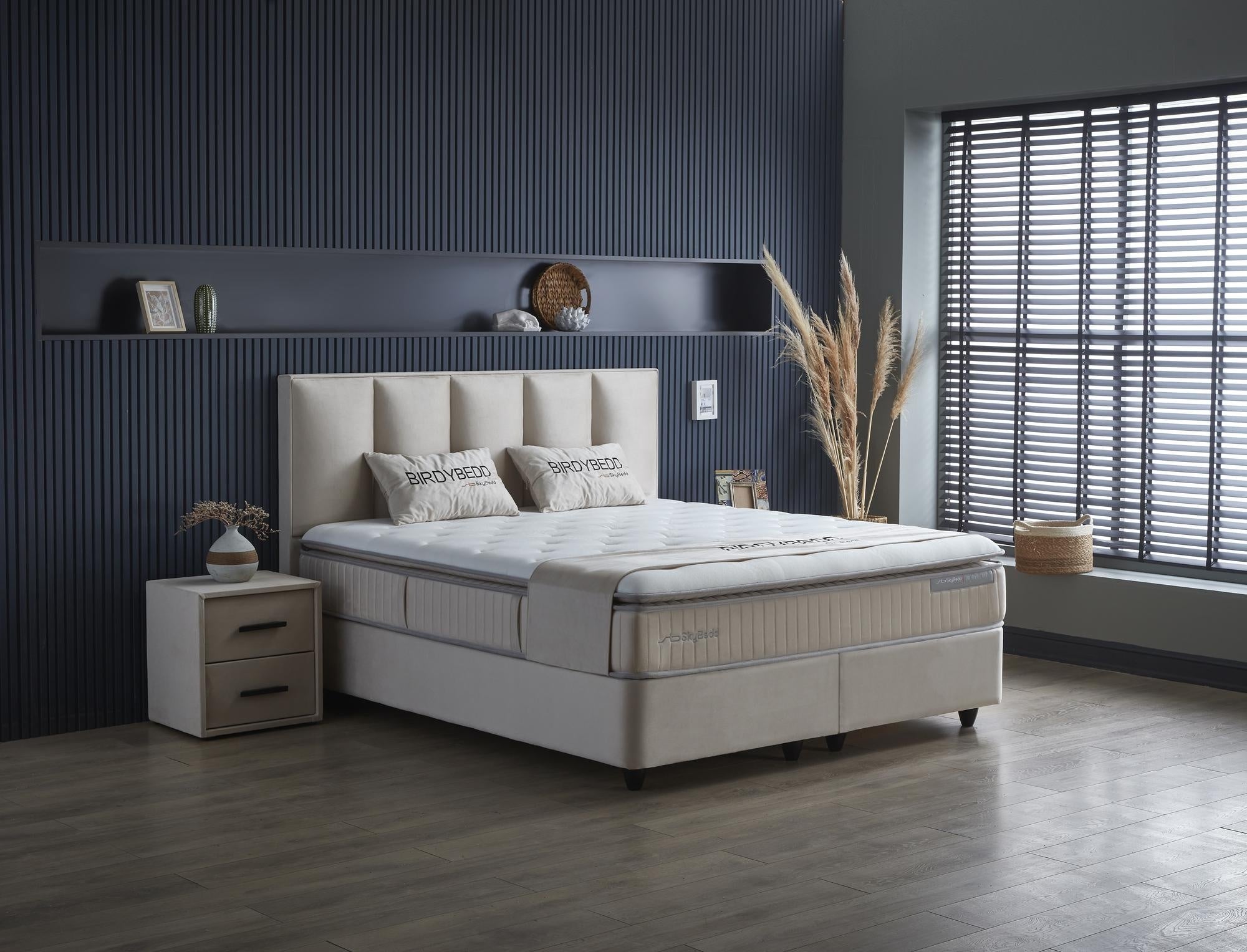Boxspringbett 'BirdyBedd' SkyBedd in Beige/Creme mit Matratze und Stauraum, präsentiert im eleganten Schlafzimmerambiente, betont Komfort und Funktionalität.