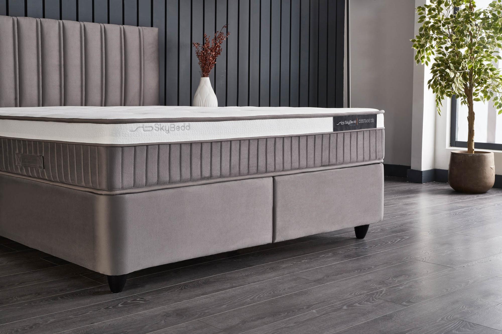 Boxspringbett 'CostaBedd' von SkyHome24.de mit weicher Matratze und Stauraum, bietet orthopädische Unterstützung und Komfort, ideal für ein günstiges, stilvolles Schlafzimmer.