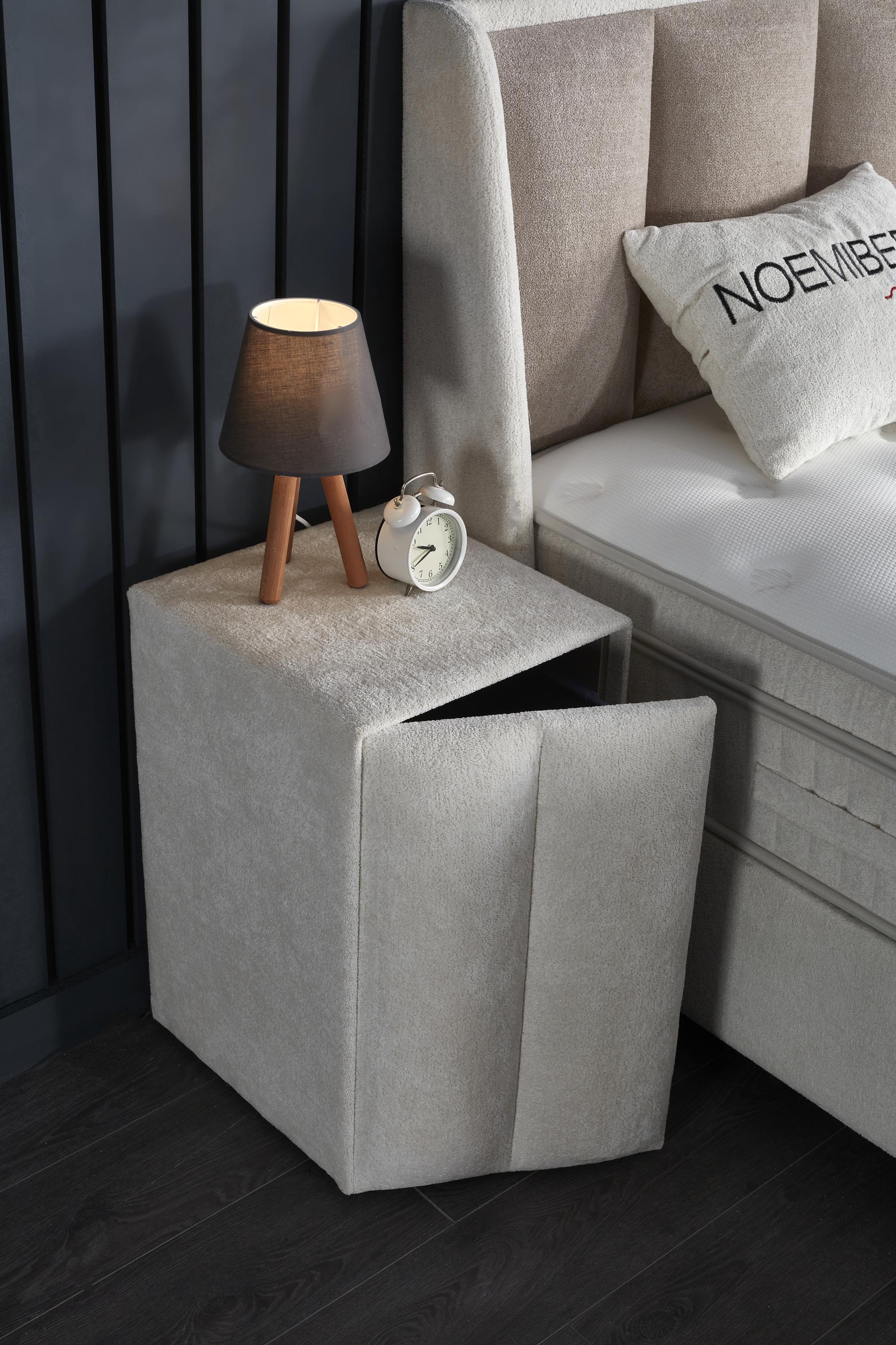 Boxspringbett 'NoemiBedd' mit integrierter Matratze und Stauraum, präsentiert mit weißen Accessoires. Produkt von SkyHome24.de, bekannt für günstige Boxspringbetten.