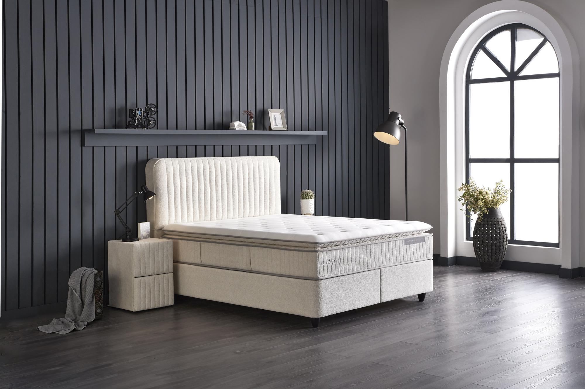 Boxspringbett 'BridaBedd' mit Matratze und integriertem Stauraum, präsentiert im stilvollen Interieur. Beliebtes Modell von SkyHome24.de, bekannt für günstige OEKO-TEX Matratzen.